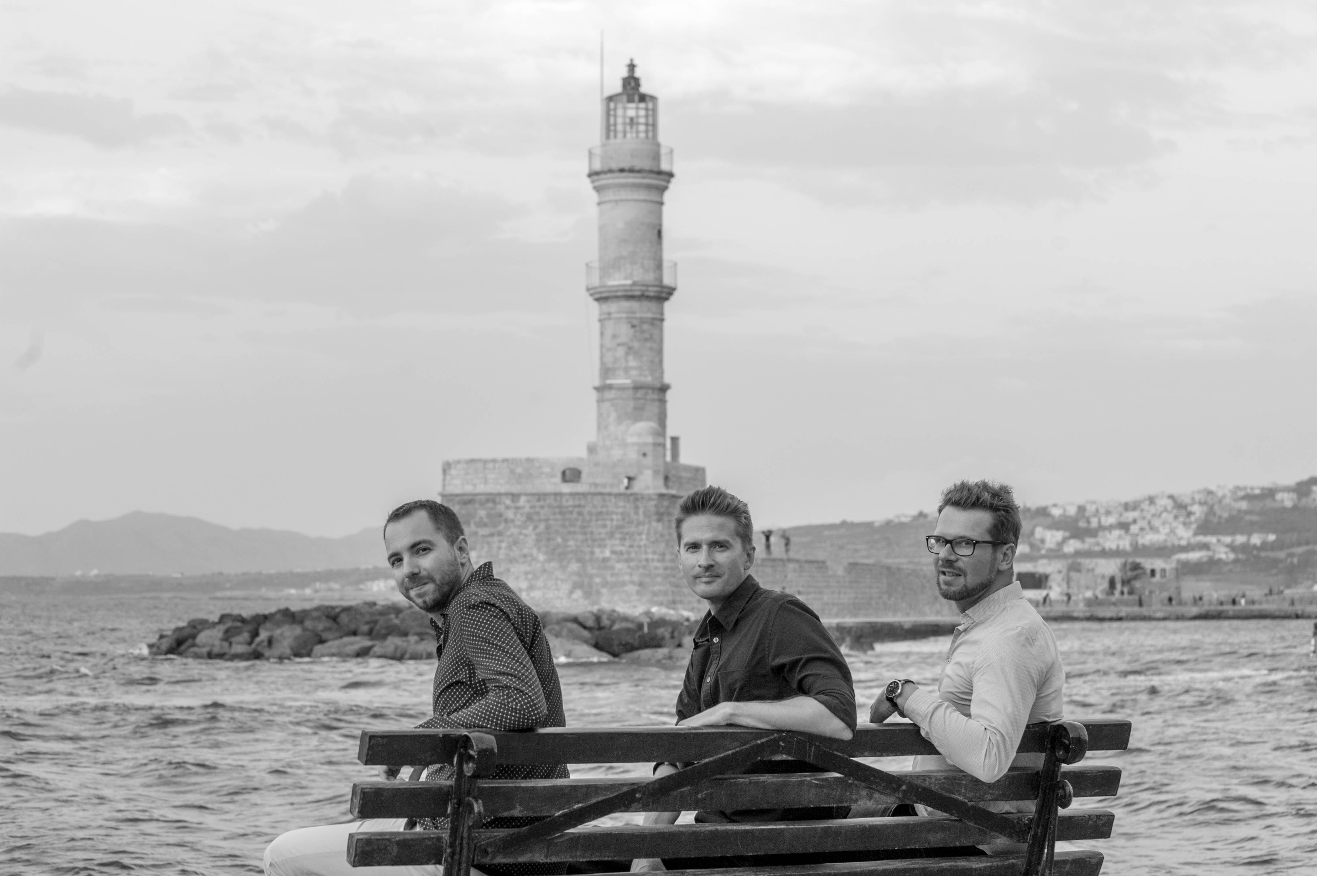 Matthieu, Lefteris and Stefan seated in front of the Chania lighthouse.